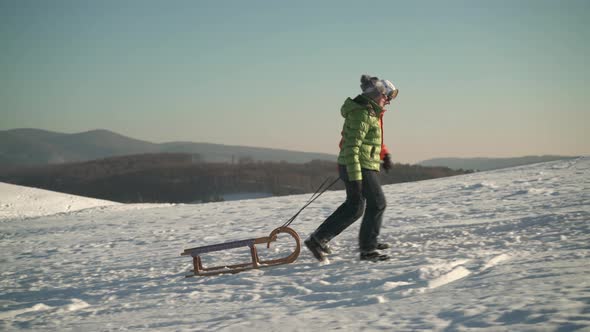 Best Ager Couple Walking up Hill With Sled