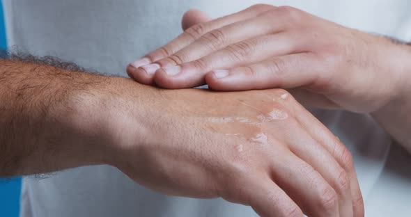 Man Applying Body Lotion on Arms for Ultra Violet Protection