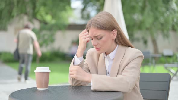 Young Businesswoman Feeling Worried in Outdoor Cafe