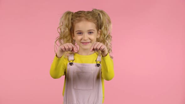 Pretty Young Girl Drawing Heart and Sending a Blow Kiss