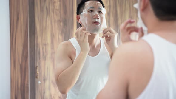 Young Asian Guy Using Face Mask in Bathroom