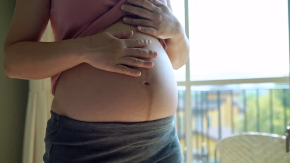 Happy Pregnant Woman and Expecting Baby at Home