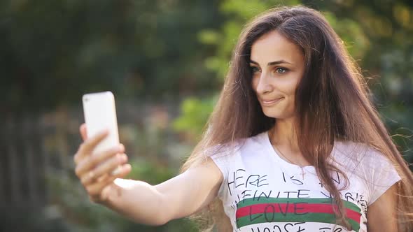 Smiling Pretty Lady Using Mobile Phone in the Park