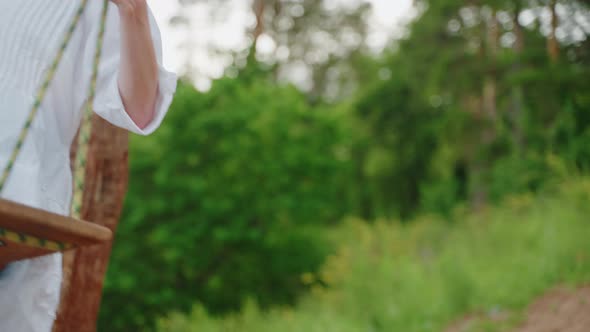 Happy Girl in White Dress in Summer in Nature Bungee Rides in Forest Outdoors