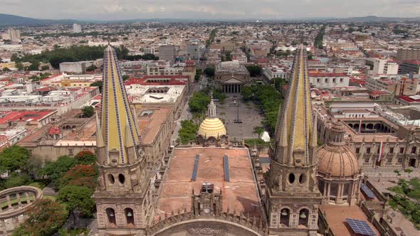 Aerial Through Neo-gothic Spires Of Guadalajara Cathedral Towards Plaza de la Liberacion In Guadalaj