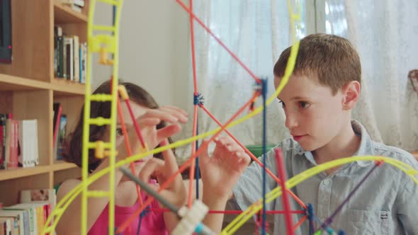 Boy and girl building a tower from toys at home