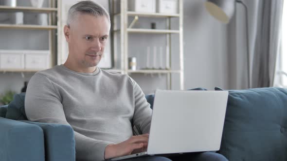 Online Video Chat on Laptop By Casual Gray Hair Man