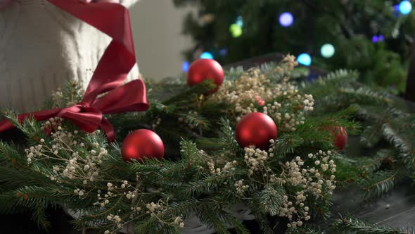 Female decorates the Christmas wreath herself on table at home