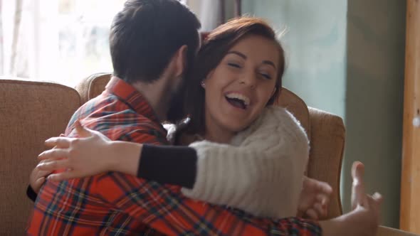 Woman receiving a gift by man in living room