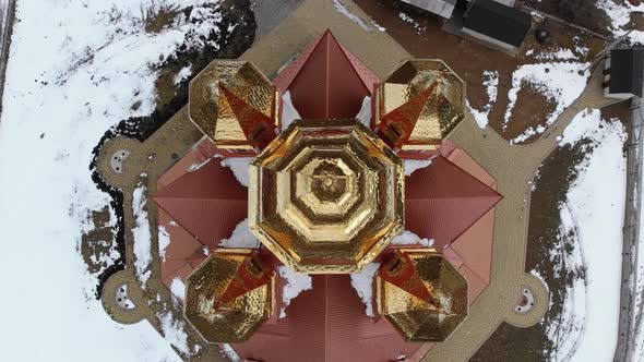 Aerial Top View on Ukrainian Church with Golden Domes in Carpathian Village in Winter alt