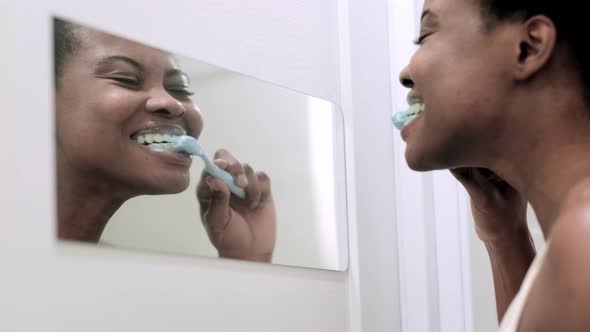 Portrait Happy Black African American Girl Brushing Teeth in the Bathroom