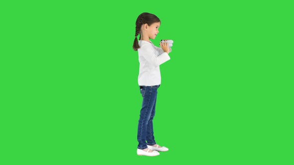 Excited Little Girl Play Videogame Holding Joystick in Her Hands on a Green Screen Chroma Key
