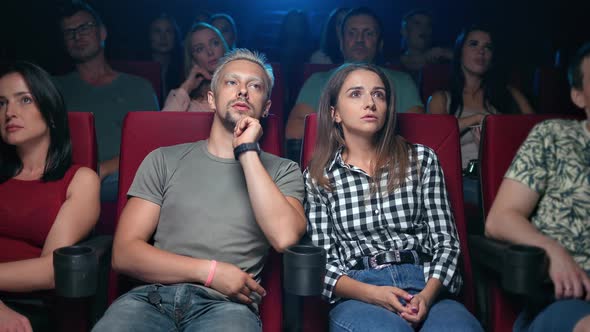 Enthusiastic Couple Watching Film at Cinema Discussing Action with Shocked Amazement Face Expression