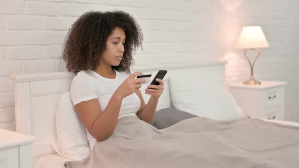 Online Shopping Failure on Smartphone By Young African Woman in Bed