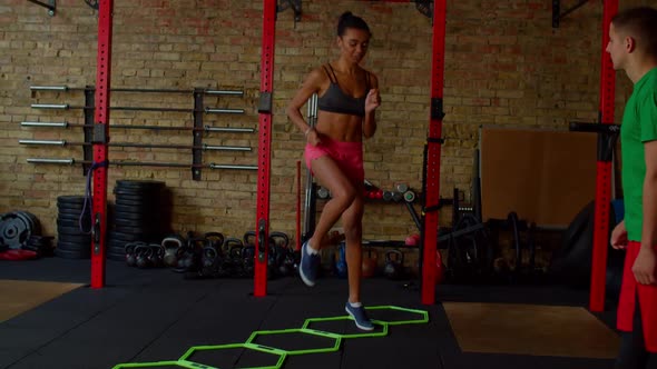 Sporty Fit Black Woman Practicing High Knee Walking Exercise with Agility Ladder