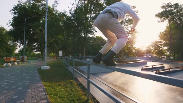 Aggressive Inline Roller Skater Doing Tricks in Concrete Skatepark Outdoors Slow Motion Tracking