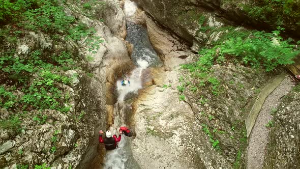 Aerial view of couple jumping in sliding rock at Soca river, Slovenia.