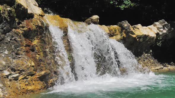 Closeup of Water Stream Flowing Down From the Cascade on a Bright Sunny Day