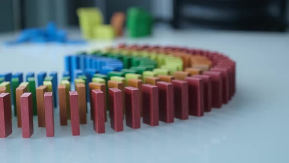 Line up of Dominoes in Rainbow Falling Colors with LGBT Colors of a Hand