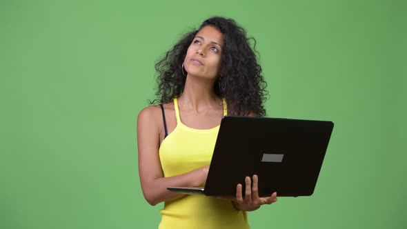 Young Beautiful Hispanic Woman Thinking While Using Laptop