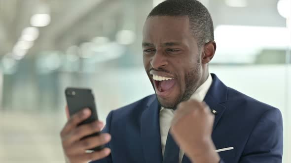 Portrait of African Businessman Having Success on Smartphone