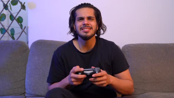 Angry Indian gamer playing video games late at night