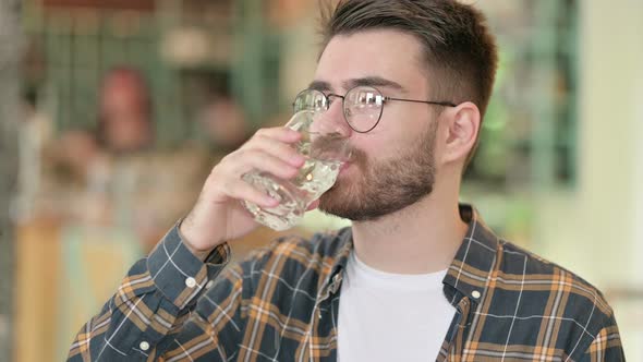 Thirsty Young Man Drinking Water From Glass 