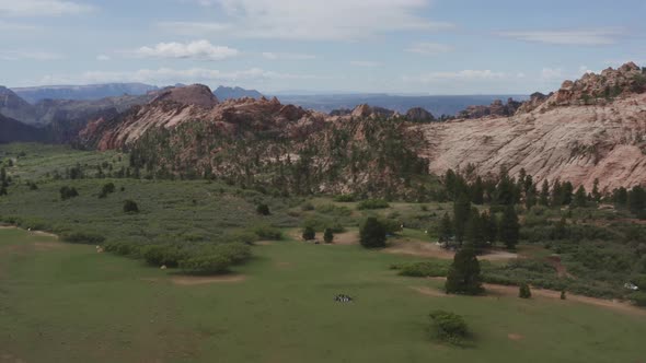 Wide drone pan of group circling on grass in Zion National Park