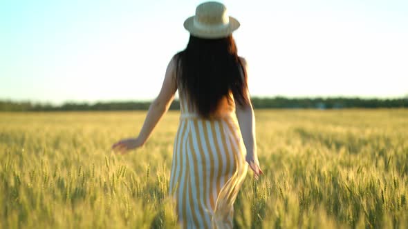 Beauty Girl with Long Hair in Dress Running on Wheat Field in Sunset Summer, Freedom Concept