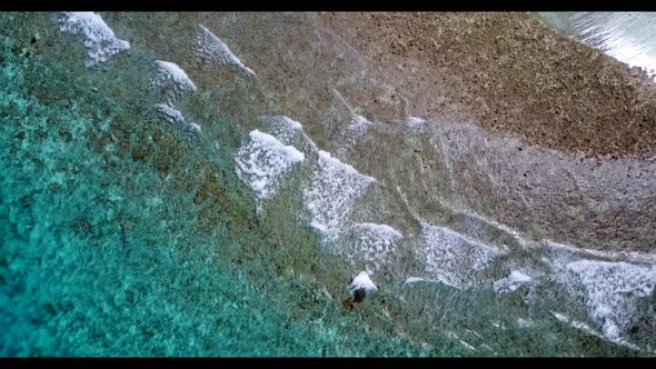 Aerial flying over abstract of tranquil tourist beach adventure by blue green ocean and white sand b