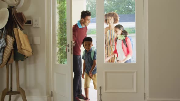 Happy african american family entering the house from front door