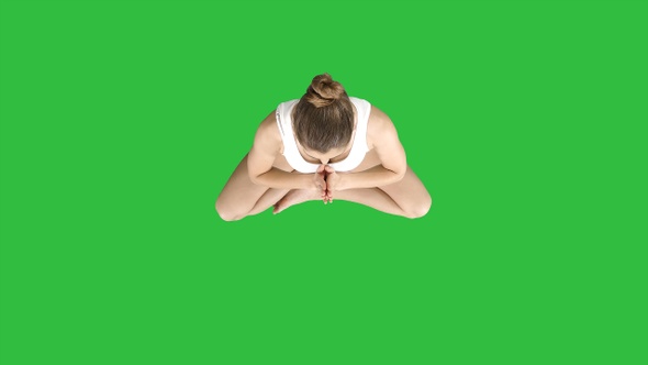 Young woman meditating in Lotus Pose on a Green Screen, Chroma Key