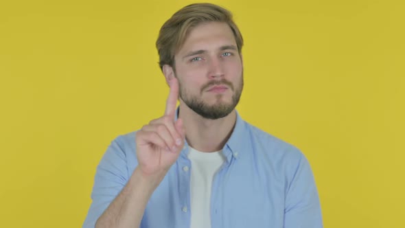 Young Man in Denial on Yellow Background
