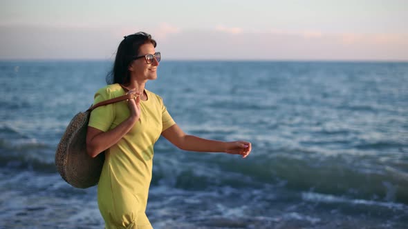 Elegant Woman in Yellow Dress Walk on Seashore Rejoicing Having Fun