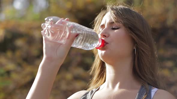 young sports girl after training drinks water