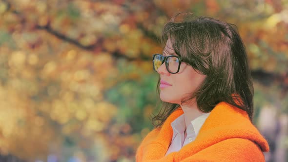 Young Beautiful Romantic Woman with Autumn Leaf in Fall Park