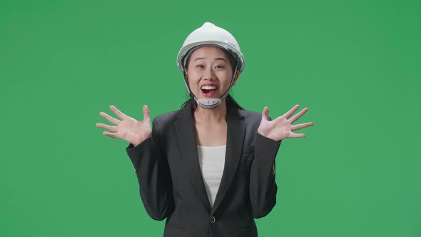 Smiling Asian Female Engineer Showing Gesture Hands Palm And Saying Wow In The Green Screen Studio