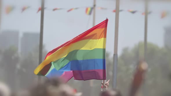 LGBTQ rainbow flag waving in slow motion during the main party in a pride parade