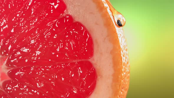 Drop of Water Flows Down the Surface of a Ripe Juicy Grapefruit Slice