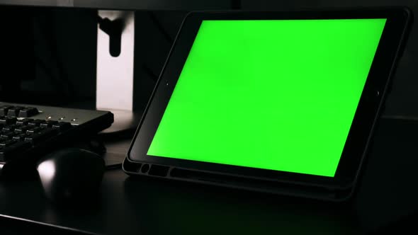 Tablet with green screen monitors on the desk