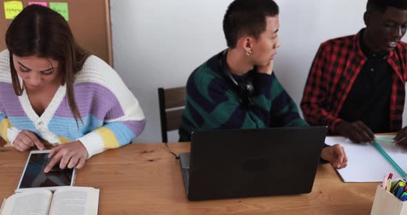 Multiracial students using laptop and digital tablet while studying together - School concept