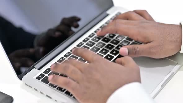 Top View of Hands of African Man Typing on Laptop 