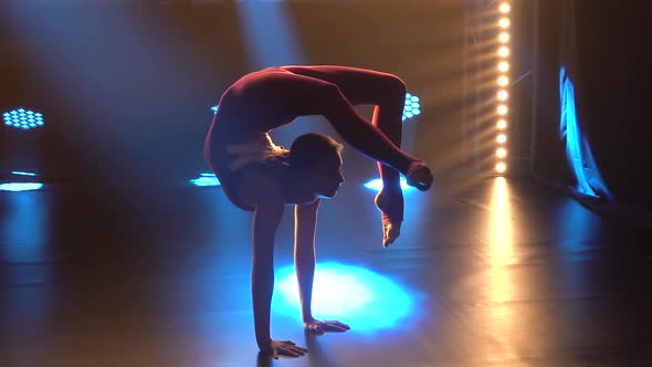 A Girl Gymnast in a Tight Sports Bodysuit Performs Gymnastics Elements and Demonstrates a Wonderful