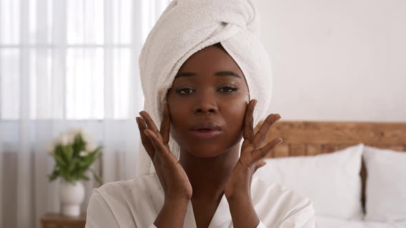 Glamorous Black Lady Applying Moisturizing Cream Touching Face In Bedroom
