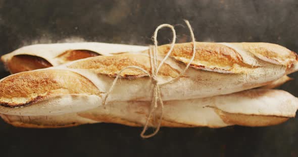 Video of baguettes tied with lace on a black surface