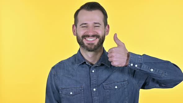 Young Man Showing Thumbs Up, Yellow Background