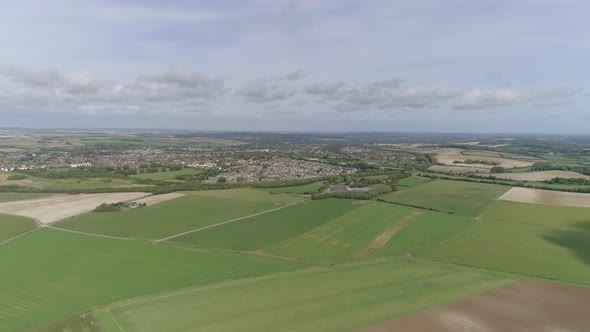 Wide aerial tracking forward toward the town of Poundbury, just outside of Dorchester, Summer weathe