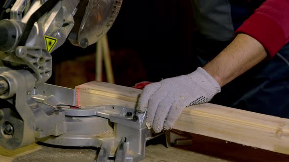 Male Carpenter Uses Circular Saw with Laser Cutting New Baseboard for Renovation