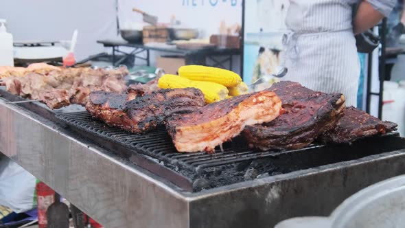 Meat Is Grilled at Street Food Festival. Large Pieces of Pork Roasted on the BBQ