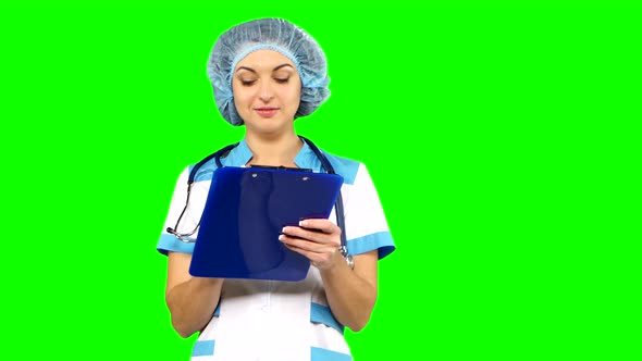 Closeup Portrait of a Female Doctor Writing on Green Screen